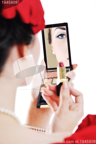 Image of beautiful young woman applying makeup