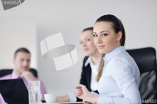 Image of business woman standing with her staff in background