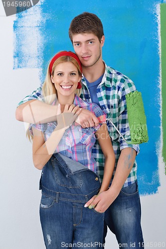 Image of happy couple paint wall at new home