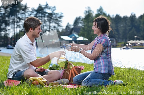 Image of happy young couple having a picnic outdoor