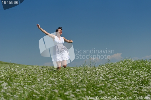 Image of Young happy woman in green field