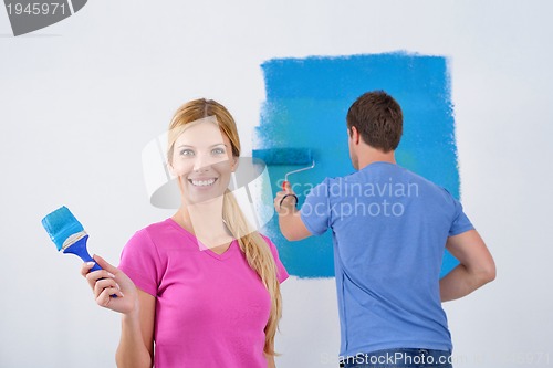 Image of happy couple paint wall at new home