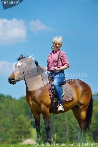 Image of happy woman  on  horse