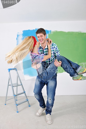 Image of happy couple paint wall at new home