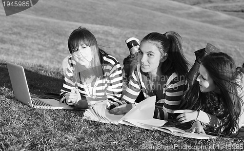 Image of group of teens working on laptop outdoor