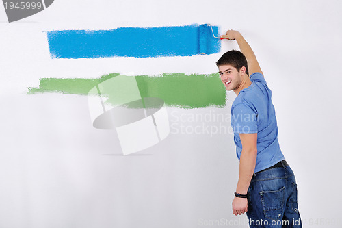 Image of happy couple paint wall at new home