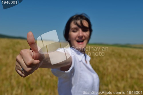 Image of young woman in wheat field at summer
