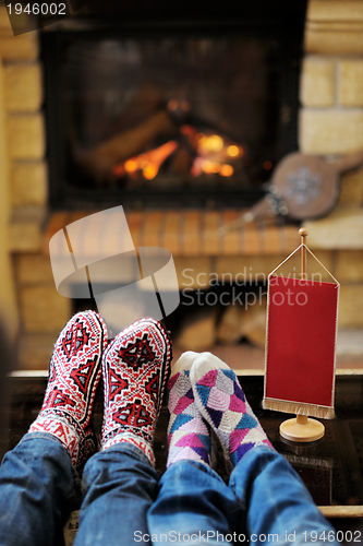 Image of Young romantic couple relax on sofa in front of fireplace at hom