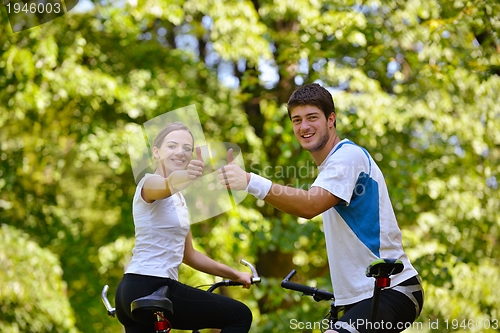 Image of Happy couple ridine bicycle outdoors