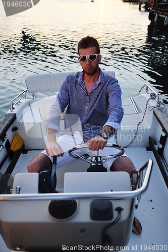 Image of portrait of happy young man on boat