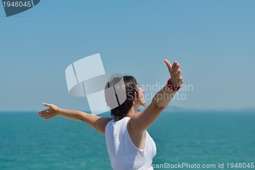 Image of happy young woman with spreading arms to sky