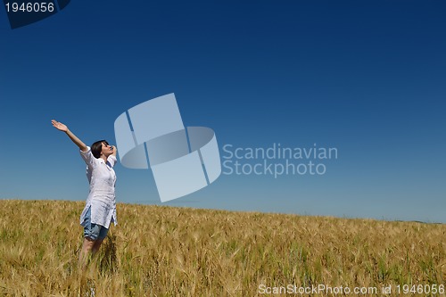 Image of young woman in wheat field at summer