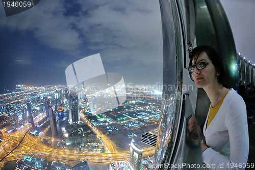 Image of beautiful woman portrait with big city at night in background