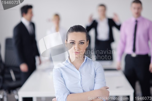 Image of business woman standing with her staff in background