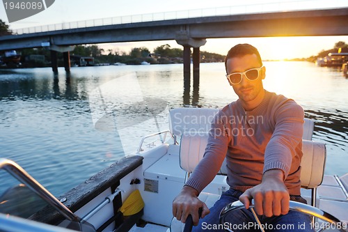 Image of portrait of happy young man on boat