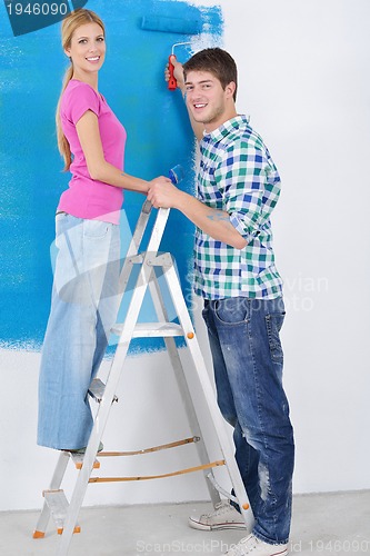 Image of happy couple paint wall at new home