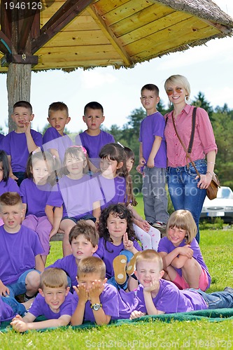 Image of happy kids group with teacher in nature