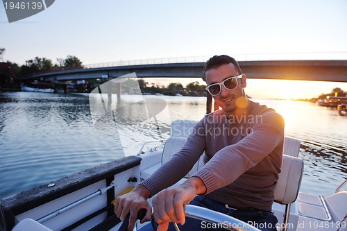 Image of portrait of happy young man on boat