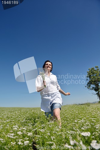 Image of Young happy woman in green field