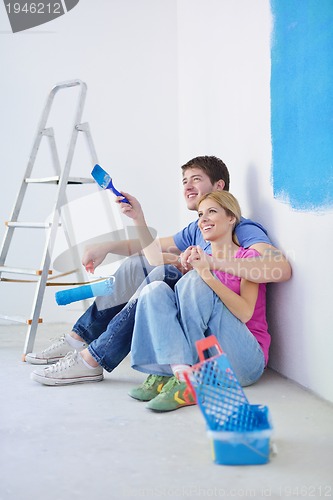 Image of happy young cople relaxing after painting in new home