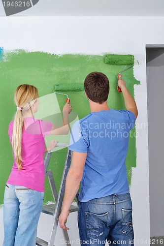 Image of happy couple paint wall at new home