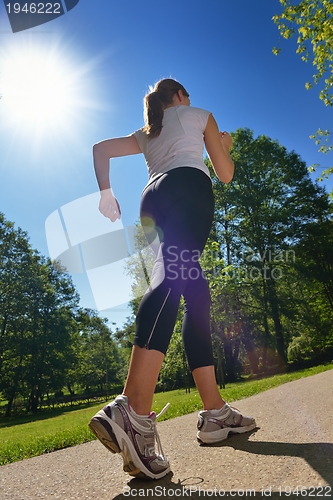 Image of Young beautiful  woman jogging at morning in park