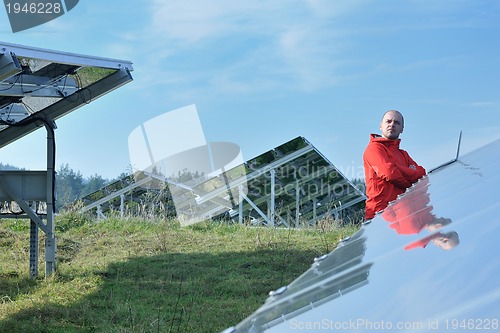 Image of engineer using laptop at solar panels plant field