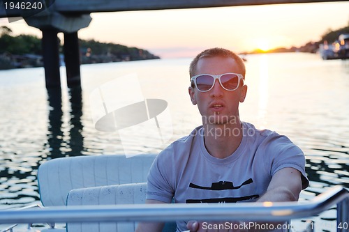 Image of portrait of happy young man on boat