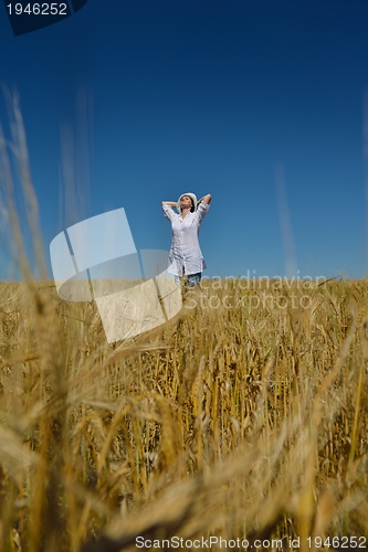 Image of young woman in wheat field at summer