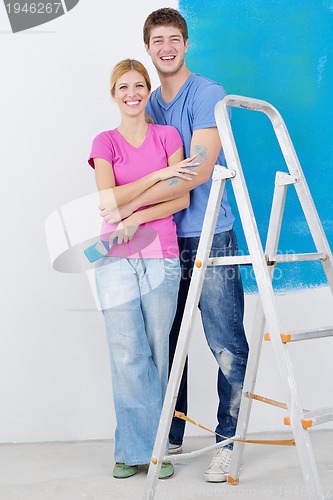 Image of happy couple paint wall at new home