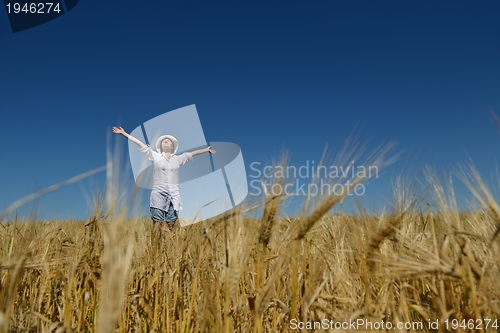 Image of young woman in wheat field at summer