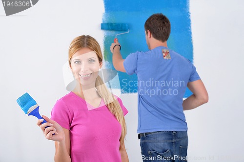 Image of happy couple paint wall at new home