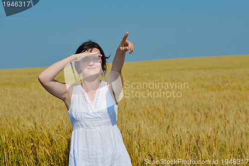 Image of young woman in wheat field at summer