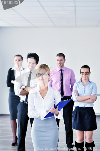 Image of business woman standing with her staff in background