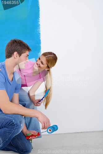 Image of happy couple paint wall at new home