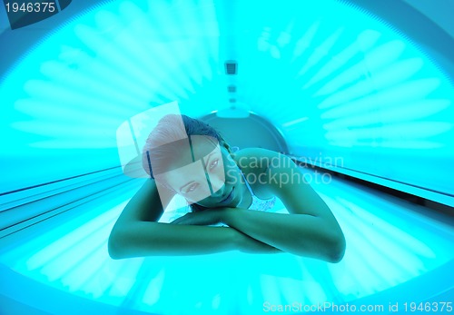 Image of Beautiful young woman tanning in solarium