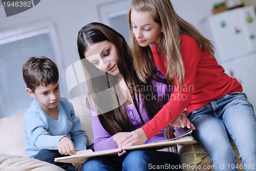 Image of young mom play with their kids at home and reading book