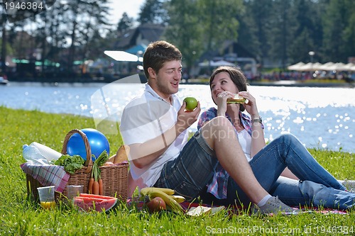Image of happy young couple having a picnic outdoor