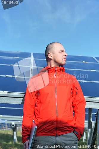 Image of engineer using laptop at solar panels plant field