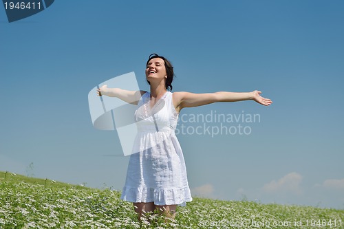 Image of Young happy woman in green field