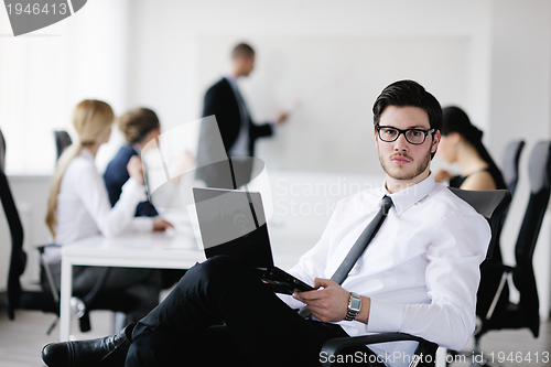 Image of Portrait of a handsome young business man with colleagues in bac