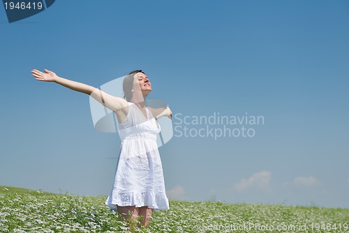 Image of Young happy woman in green field