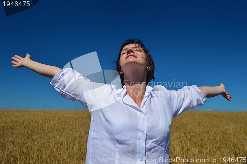 Image of young woman in wheat field at summer