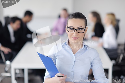 Image of business woman standing with her staff in background
