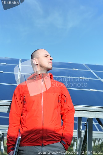 Image of engineer using laptop at solar panels plant field