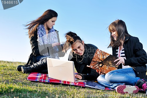 Image of group of teens working on laptop outdoor