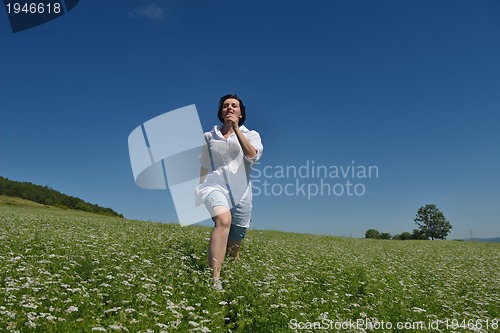 Image of Young happy woman in green field