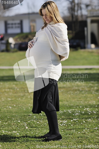 Image of happy young pregnant woman outdoor