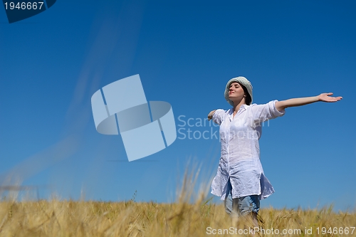 Image of young woman in wheat field at summer