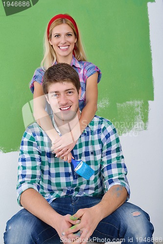 Image of happy couple paint wall at new home